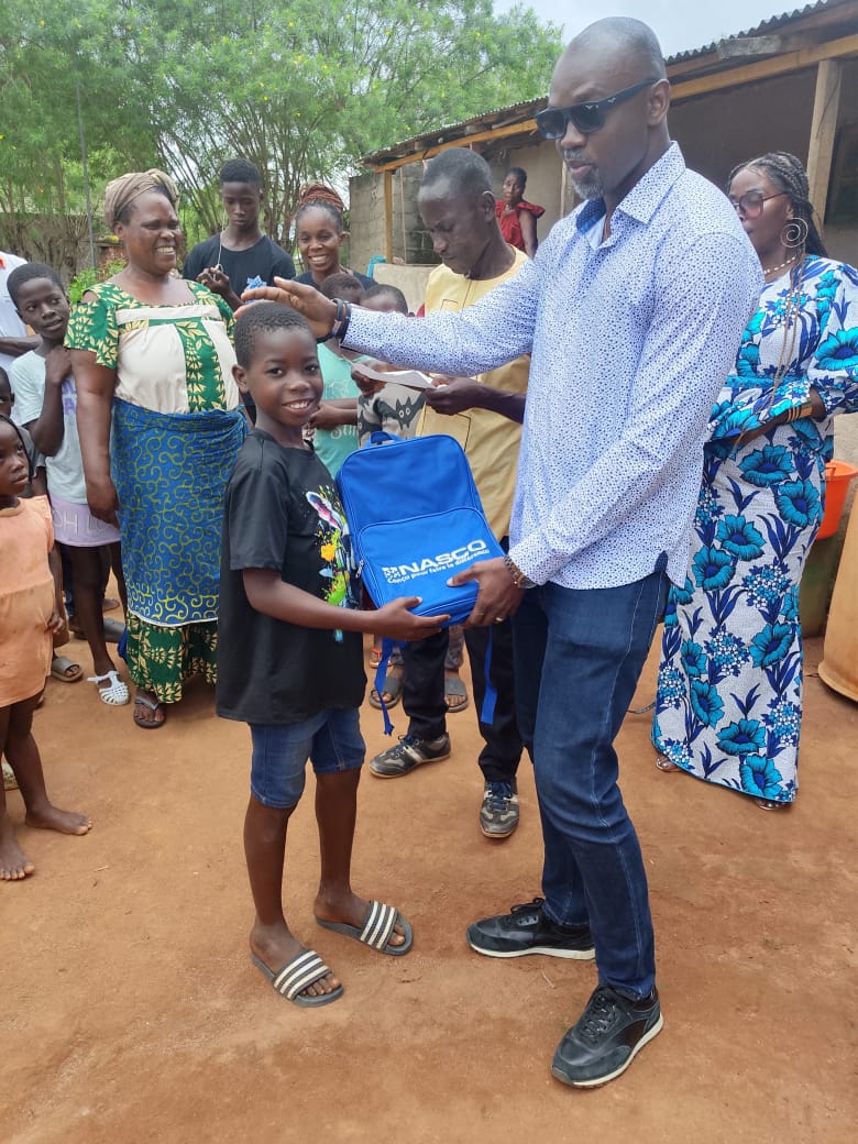Gnolou GUERO remet un cartable à un jeune élève