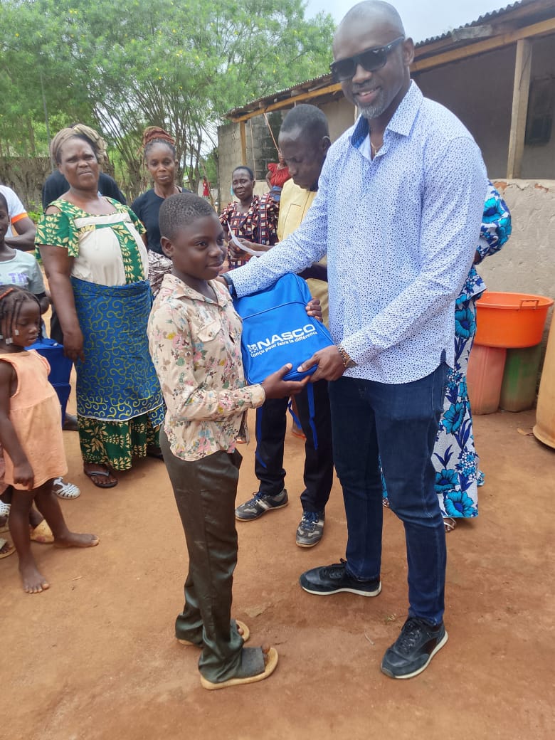 Gnolou GUERO remet un cartable à un élève